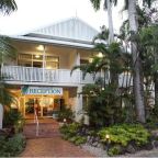 This Queenslander style building peeps through tropical palms - Palm Villas